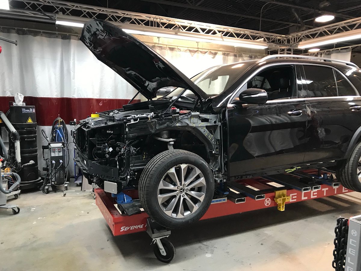 Mercedes-Benz SUV with front panels removed during a collision repair managed by Eric Ryckman